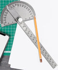 No Fuss Stainless Steel Zero To One Eighty Degree Round Head Protractor And Angle Finder on workspace with pencil.