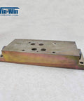 Waterjet hydraulic manifold top-mount, side view; metal block with multiple top holes and mounting holes.