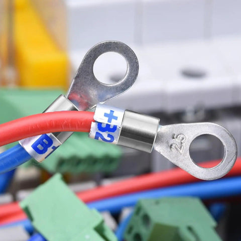 Electrical cables with metal ring terminals connected to labeled equipment, showing a close-up of wire organization.