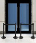Built Tough Heavy Duty Black Crowd Control Stanchions With Premium Steel, 6.5 Foot Retractable Belt Safety Barriers in front of doors