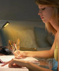 Woman using Clip-On Reading Light for Books in Bed, Car and Travel, 3000K Warm LED, Rechargeable and Eye Friendly, writing in notebook