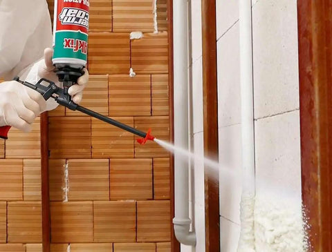 No Fuss Fire Rated Spray Foam Insulation Kit Covers 240 Square Feet being applied with trigger gun to wall insulation.