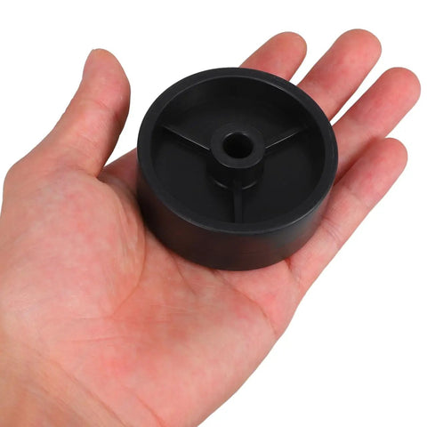 Close-up of a black 97mm wheel from Universal Patio Heater Wheel Kit 4 Pack, shown in a person's hand for scale.