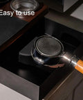 Heavy Hitter Double Tier Solid Wood Espresso Tamping Station With Combo Knock Box Premium Handcrafted Coffee Bar Organizer Kit showing portafilter in knock box.