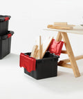 Haul Heavy Loads With Ease Using These Tough As Nails 12 Gallon Storage Totes With Secure Lids For Garage Organization Stackable Heavy Duty Crates Featuring Tie Down Grommets In A Rock Solid 12 Pack Bundle filled with wooden planks on a workbench.