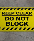 High Visibility Keep Clear Floor Sign No Sweat Heavy Duty Peel And Stick Adhesive For Commercial Spaces Bold Graphics Straight Up Easy Mount 12 By 9 Inch Safety Stickers on concrete floor.