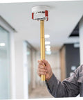 Slick Aluminum Smoke Sensor Removal Tool For Ceilings Universal Fire Alarm Disassembly Grip held upwards by hand.