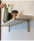 Premium Corner Shelf Brackets For Floating Wall Shelves And Rustic Industrial L Shape Supports With A Sleek Matte Black Finish And Hella Sturdy Powder Coated Steel Hardware Kit on a white shelf.