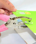 Close-up of Two Pack 1/16 And 1/8 Inch Circle Hole Punches For DIY Crafts And Scrapbooking handheld tool in use on paper.