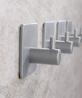 Heavy Duty White Bathroom Wall Hooks Set Featuring A No Fuss Towel Rack Sturdy Toilet Paper Holder And Slick Coat Hanger mounted on a wall.