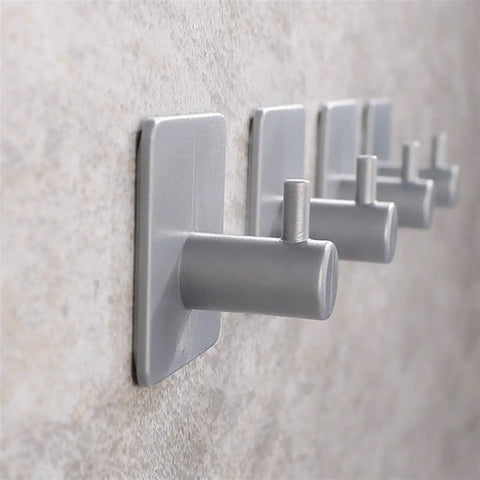 Heavy Duty White Bathroom Wall Hooks Set Featuring A No Fuss Towel Rack Sturdy Toilet Paper Holder And Slick Coat Hanger mounted on a wall.