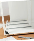 Folding table hinge replacement kit installed on partially assembled furniture, showcasing steel hinges and spring mechanism for sturdy support.