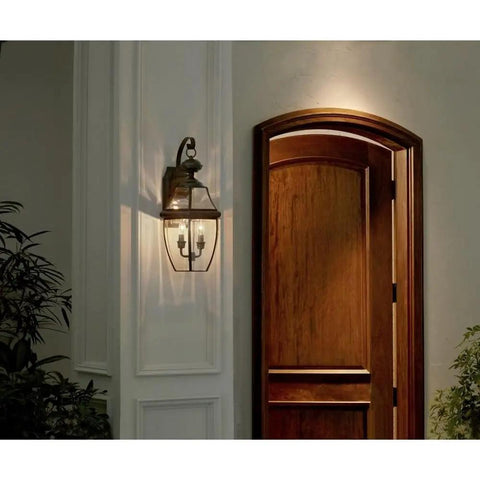 Two Light Outdoor Wall Lantern In Antique Brass Finish For Patio And Entry, classic Newbury style mounted by door, 20" high.