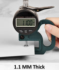Close-up of a caliper measuring 1mm thickness of Peel And Stick White Marble Vinyl Floor Tiles 12x12 Inch 1mm Thick Waterproof Self Adhesive Flooring