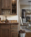 Kitchen with wooden cabinets and countertop, featuring antique brass cabinet knobs, glassware, and decorative items.