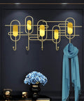 Heavy Duty Iron Wall Hooks Game Changer Home Upgrade For Entryways And Bedrooms Decor Sturdy Metal Coat Rack With Sleek Finish that holds a scarf and decor.