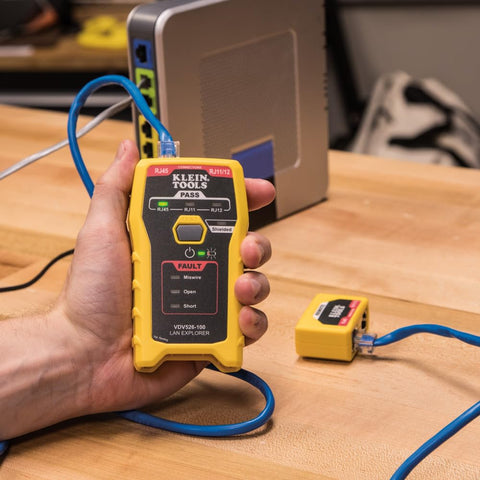 Person using RJ45 Ethernet Cable Tester And Crimper Kit With Pass Thru Technology for Cat5e and Cat6 data runs, yellow device