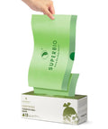 Person pulling a 13 Gallon Compostable Drawstring Kitchen Waste Bag from a box, showing tear-free heavy-duty design and certifications.
