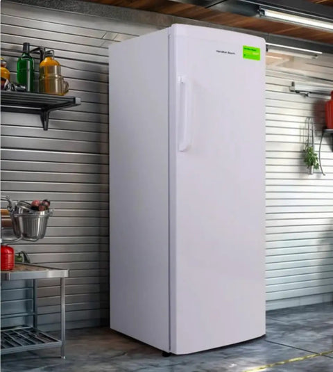 Straight Up Spacious 11 Cubic Foot Upright Freezer With Built In Drawer Organizer And Easy Manual Defrost in a garage setting.