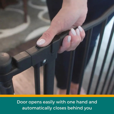 Hand operating latch on Extra Wide Windsor Arch Walk-Through Pet Gate 38.3 To 72 Inches Wide, 30 Inches Tall, Matte Bronze