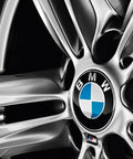 Close-up of BMW hubcap on wheel, silver spokes, showing BMW Hubcap Replacement 36 13 6 783 536 Black Fits Most Original BMW Wheels For 1 Series