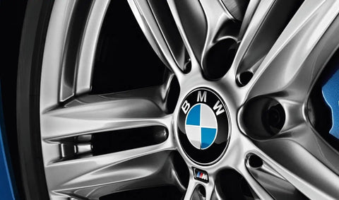 Close-up of BMW hubcap on wheel, silver spokes, showing BMW Hubcap Replacement 36 13 6 783 536 Black Fits Most Original BMW Wheels For 1 Series