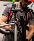 Man using XTC2 Tilt Hitch Mount Bike Rack For Two Bikes With Platform Carrier, demonstrating sturdy hook system.