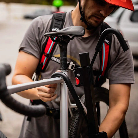 Man using XTC2 Tilt Hitch Mount Bike Rack For Two Bikes With Platform Carrier, demonstrating sturdy hook system.