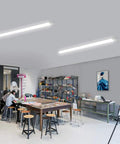 Brightly lit room with Two Pack Linkable LED Shop Lights 2ft And 4ft Waterproof Tubes 5000K under cabinet lighting, workshop setting.