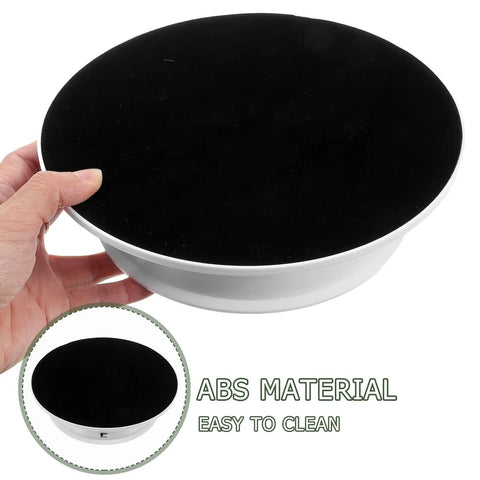 Spinning 360 Electric Turntable With Adjustable Dual Speeds For Jewelry Watch Showcase And Photography Shots Using Sleek Plastic Base held in hand with black top.