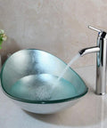 Artistic Tempered Glass Oval Vessel Sink Above Counter with Chrome Faucet and Pop Up Drain in Silver Finish Durable Brass Faucet Smooth Glass Basin Modern Bathroom Upgrade for a Sleek No Fuss Setup, shown with water flowing from faucet in a sleek bathroom setting.