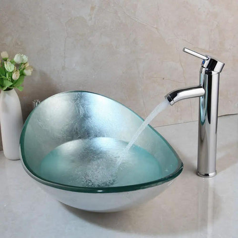 Artistic Tempered Glass Oval Vessel Sink Above Counter with Chrome Faucet and Pop Up Drain in Silver Finish Durable Brass Faucet Smooth Glass Basin Modern Bathroom Upgrade for a Sleek No Fuss Setup, shown with water flowing from faucet in a sleek bathroom setting.