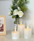 Clear Glass Flameless Candles With Timer And Remote Control Battery Powered LED Pillar Candles Set Of 3 In White Wax on a table