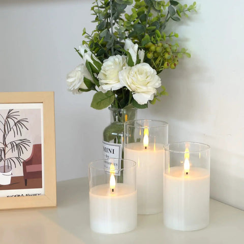 Clear Glass Flameless Candles With Timer And Remote Control Battery Powered LED Pillar Candles Set Of 3 In White Wax on a table