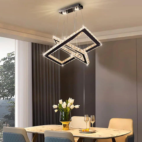Lit LED Two Ring Rectangular Crystal Chandelier Pendant Light In Stainless Steel over dining table.