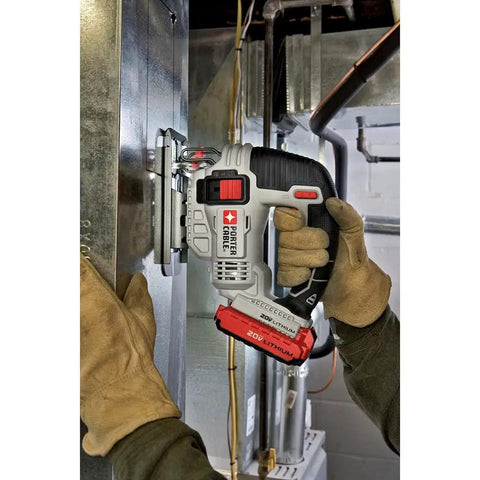 Close-up of Shop Tested 20V Max Cordless Jigsaw, held in gloved hand, cutting through metal, showcasing easy swap blade clamp feature.