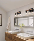 Four Light Wood Vanity Light Fixture Over Mirror With Dope Clear Glass Shades And Matte Black Metal in bathroom setting.