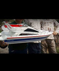 2.4G Wireless RC Speed Demon Racing Boat With Luxury Yacht Styling, Realistic Hull, held by three hobbyists outdoors
