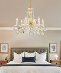 Modern Crystal Chandelier Light Fixture With Six Lights, Raindrop Pendant Crystals In Maria Theresa Brass Finish, in bedroom