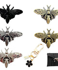 Five bee-shaped turn-lock clasps in dark/antique finishes; includes a bee-themed keychain and a black studded clutch purse.