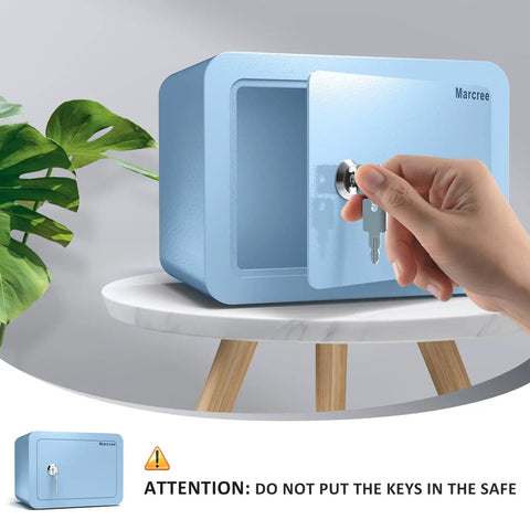 Hand opening Kid Safe Mini Safe Box With Key Lock, Steel Money Box Safe For Cash And Valuables, Compact Blue Home Safe, 6.69 X 9.06 X 6.69 Inches with key on table.