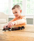 Child playing with One Sixty Fourth Magnum Red Rumbler Pulling Tractor With Sled For Collectors And Kids Three Plus Realistic Roll Bar