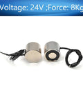 Two Pack 24V Electric Lifting Magnet With 8 Kg Pull, Circular Suction Cup Electromagnet showing two round metal devices with wires.