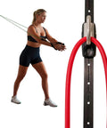 Premium Space Saver Gym Mount With One Steel Rail And One Quick Slide Car To Dominate Your Daily Grind Durable Wall Anchor System Fits Most Elastic Resistance Tubing Bands Without Including Resistance Bands in use with a person using elastic bands.