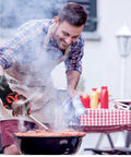 Man using BBQ Gloves Heat Resistant Up To 1472 Fahrenheit Silicone Non Slip Long Kitchen Gloves for grilling at a barbecue.