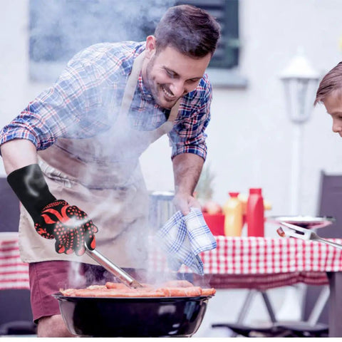 Man using BBQ Gloves Heat Resistant Up To 1472 Fahrenheit Silicone Non Slip Long Kitchen Gloves for grilling at a barbecue.