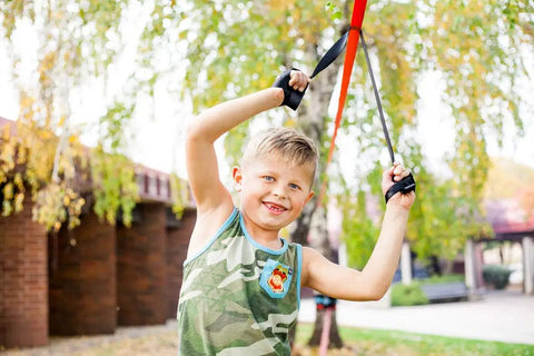 Child on Slackline Kit With Overhead Training Line, Arm Trainer in park