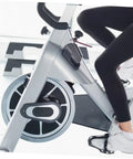 Person using indoor cycling bike for home gym with non slip caliper brake pads focusing on smooth braking and universal fit.