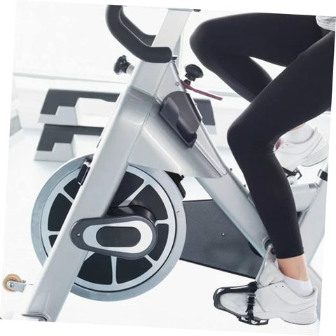Person using indoor cycling bike for home gym with non slip caliper brake pads focusing on smooth braking and universal fit.