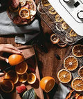 Digital Electric Food Dehydrator With Four Stackable Stainless Steel Trays and Precision Temperature Controls Featuring A Rock Solid Forty Eight Hour Timer For Sick Fast Jerky Fruit Veggie And Herb Preservation with sliced oranges on wooden board.